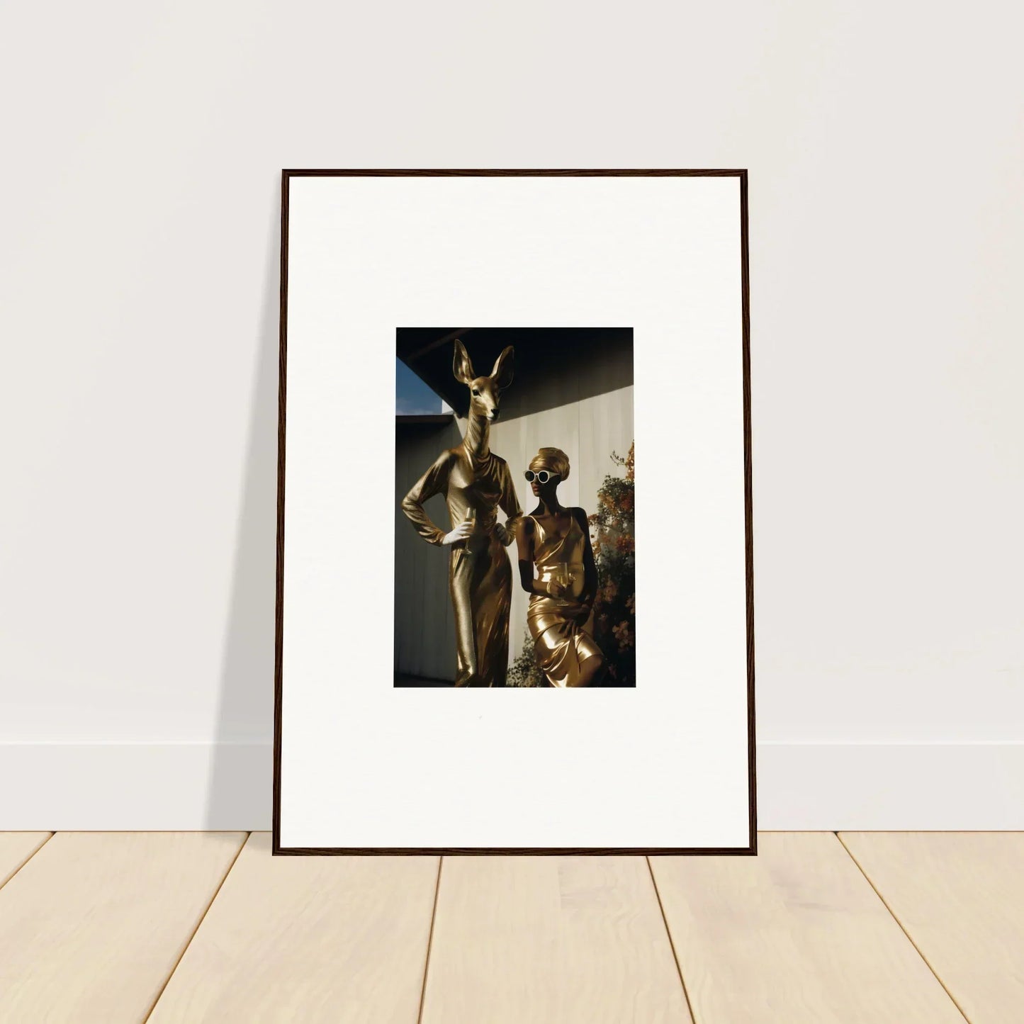 Framed photograph of two metallic humanoid figures in a standing pose.