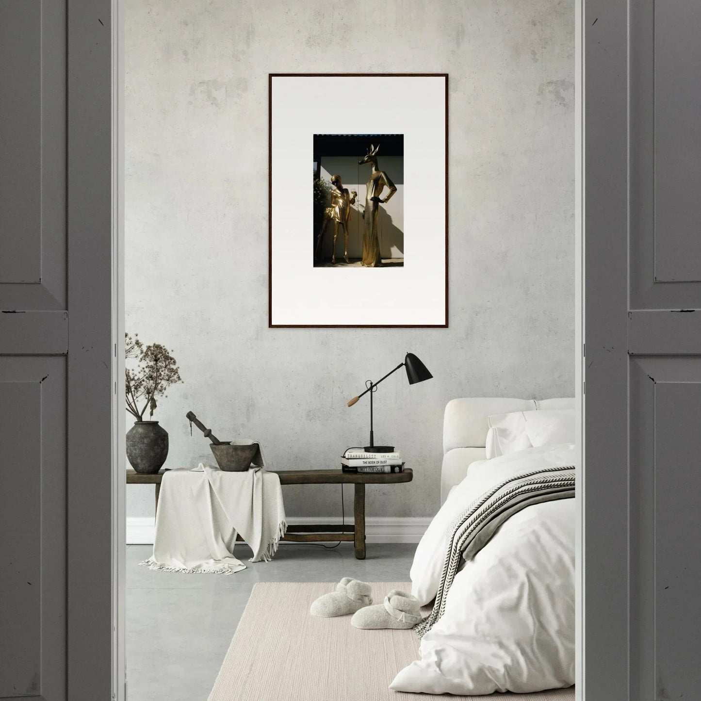 Framed artwork depicting figures in a dark, moody style hanging on a light-colored wall.