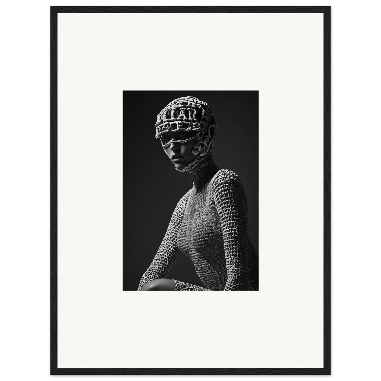 Black and white photograph of a sculptural bust wearing a textured headdress and mesh top.