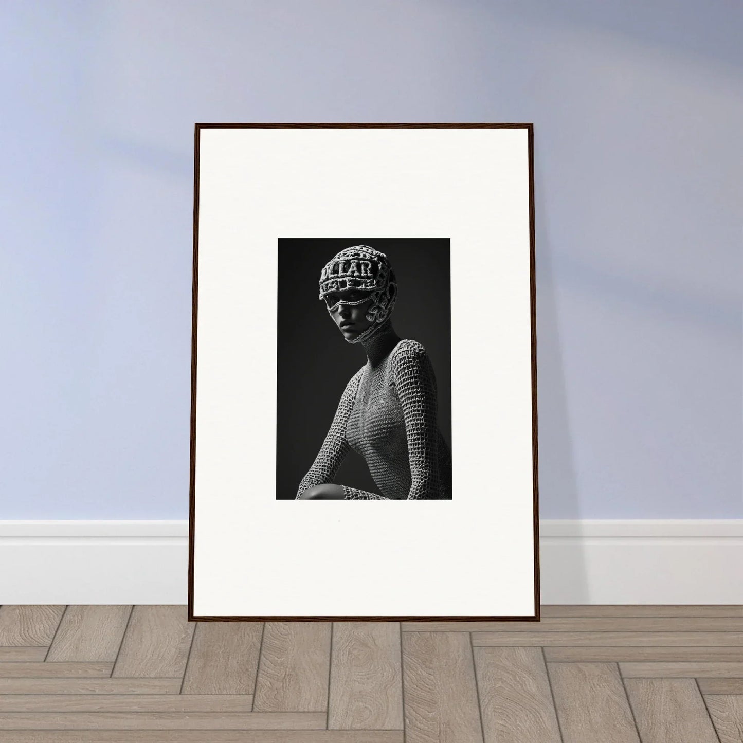 Framed black and white photograph of a person wearing a patterned headpiece and textured top.