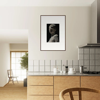 Modern kitchen with wooden cabinetry and a framed black-and-white portrait on the wall.