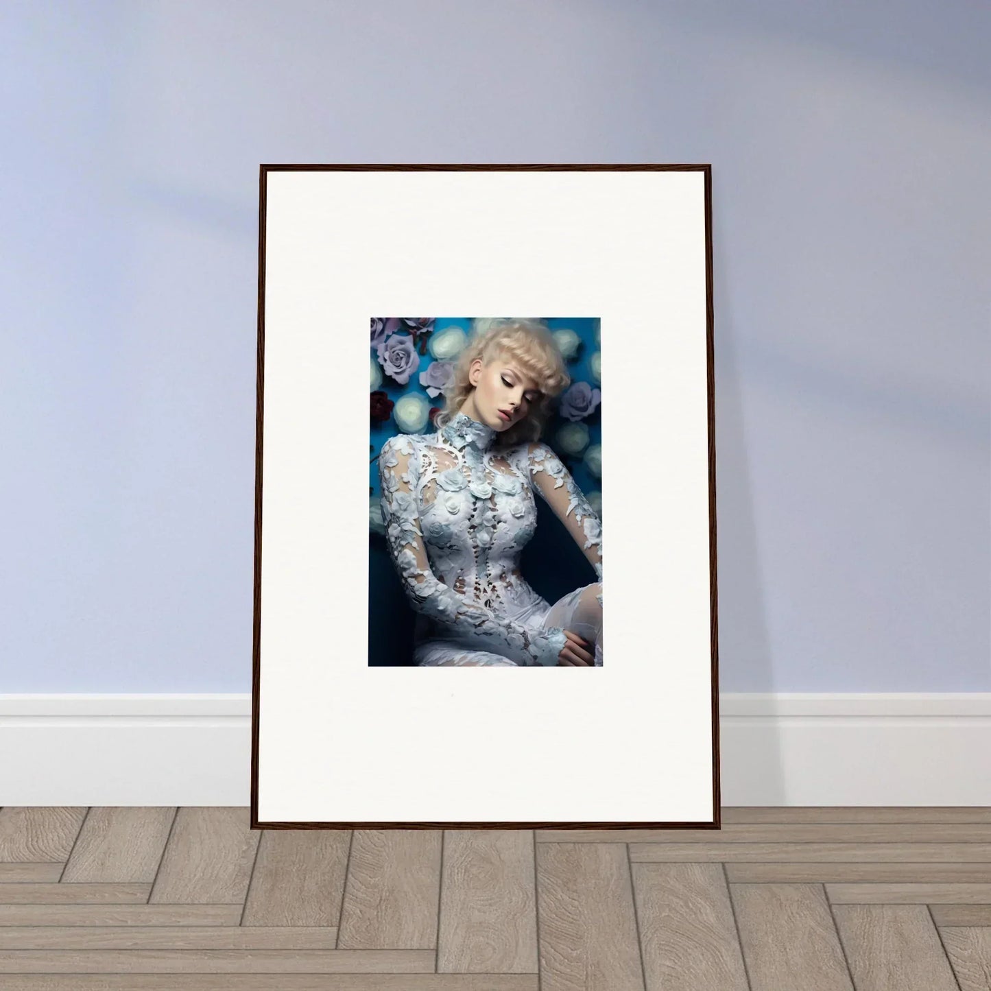 Framed portrait photograph of a woman with blonde hair in an ornate white outfit against a blue background.