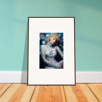 Framed photograph of a woman with blonde hair wearing an ornate white lace outfit against a blue background.