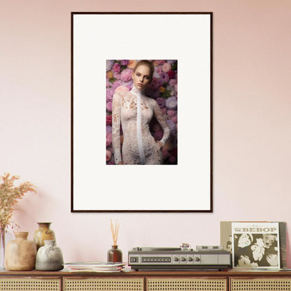 Framed portrait of a woman in a white lace dress surrounded by pink flowers.