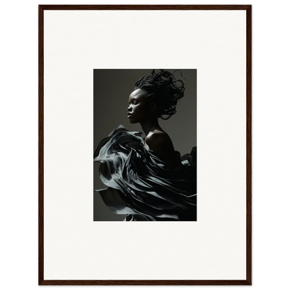 Black and white photograph of a person with flowing fabric in motion, framed in a brown frame.