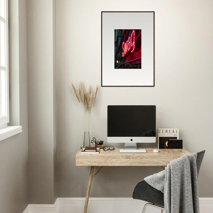 Minimalist workspace featuring a wooden desk, computer, and Night Vibrance wall art