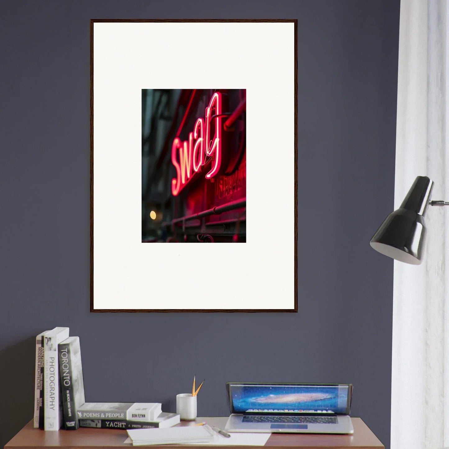 Framed wall art of a neon Swag sign showcasing night vibrance on a gray wall