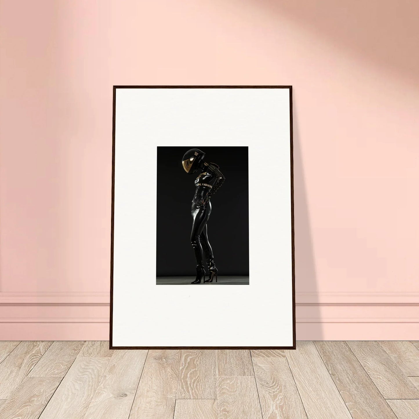 Framed black and white photograph of a figure in a sleek, shiny bodysuit striking a dramatic pose.