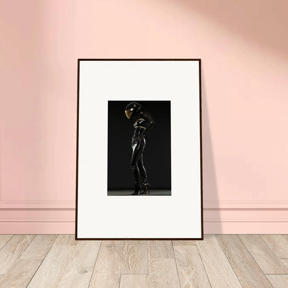 Framed black and white photograph of a figure in a sleek, shiny bodysuit striking a dramatic pose.