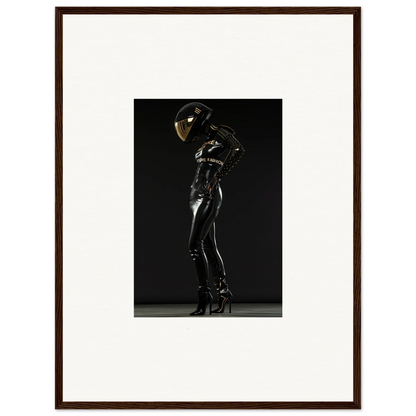 Framed photograph of a person in a shiny black bodysuit and helmet posing dramatically.