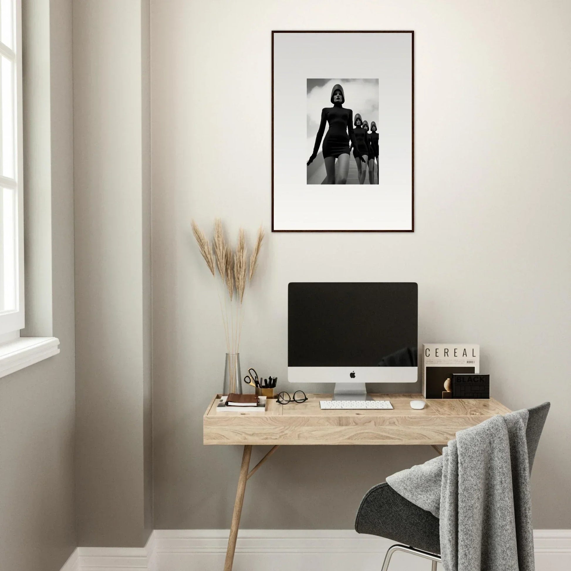 Minimalist home office with wooden desk, computer, and Venus Phantoms framed wall art