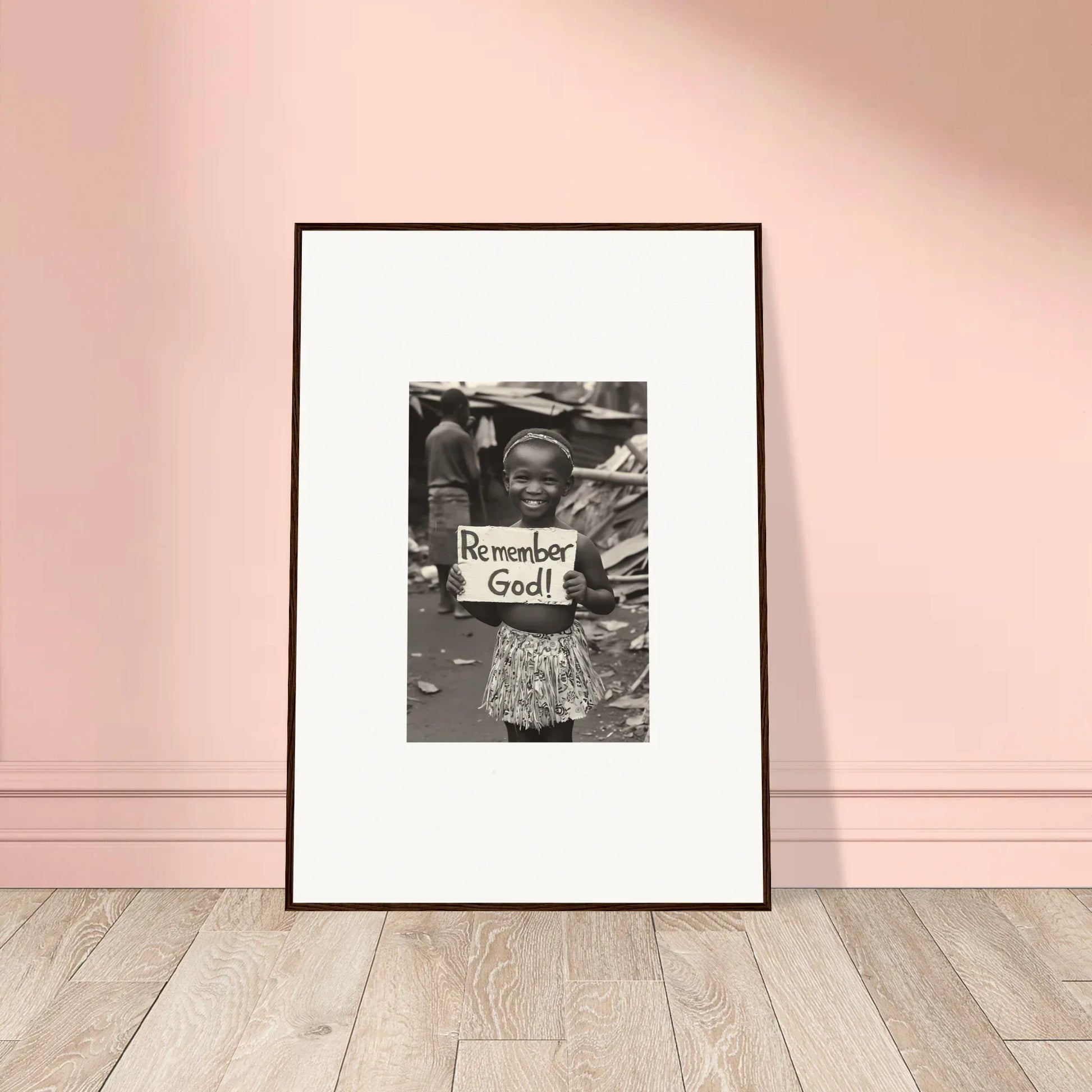 Framed black and white art of a person holding a Remember God sign in Memory Yet Flowered