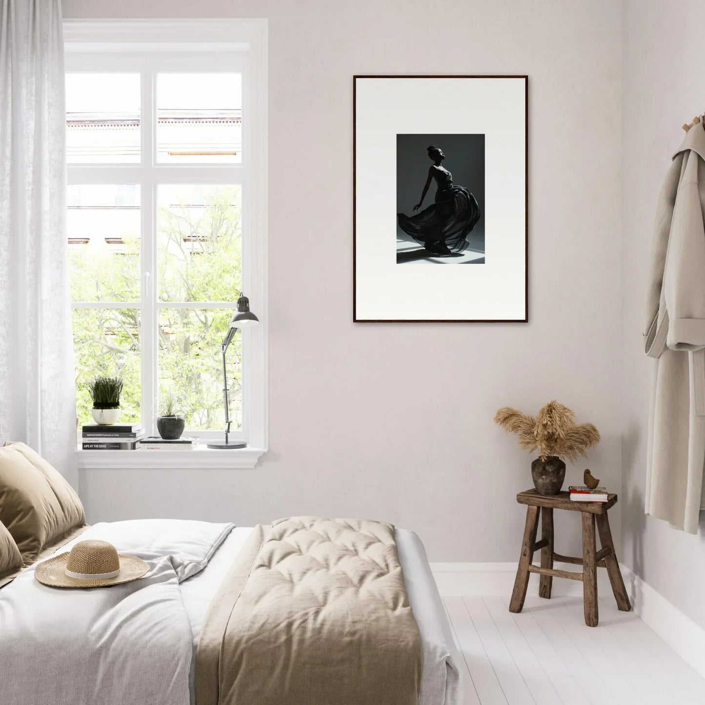 Cozy bedroom with light neutral decor and a framed black-and-white photograph on the wall.