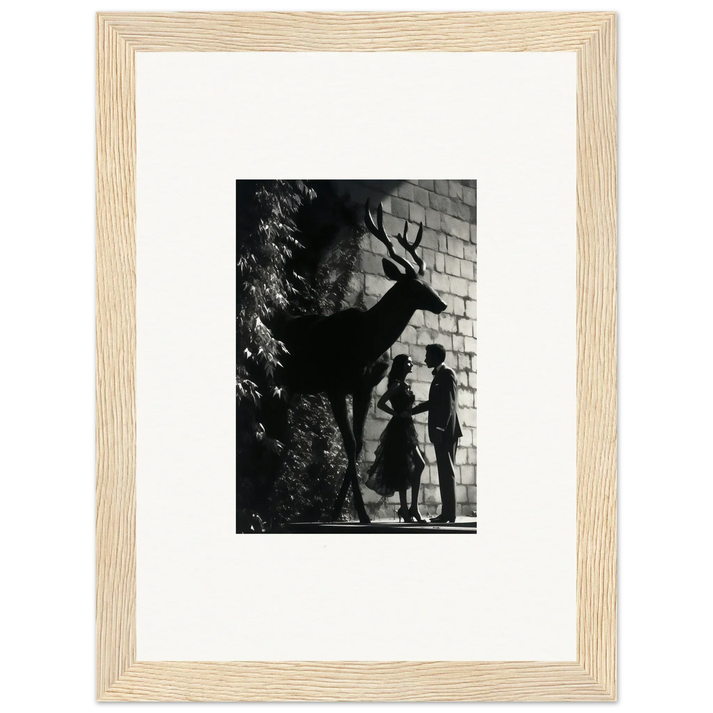 Framed black and white photograph showing silhouettes of a deer and two people against a wall.