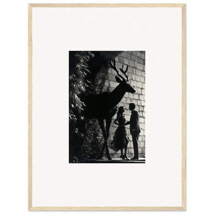 Black and white photograph showing silhouettes of two people and a deer against a brick wall.