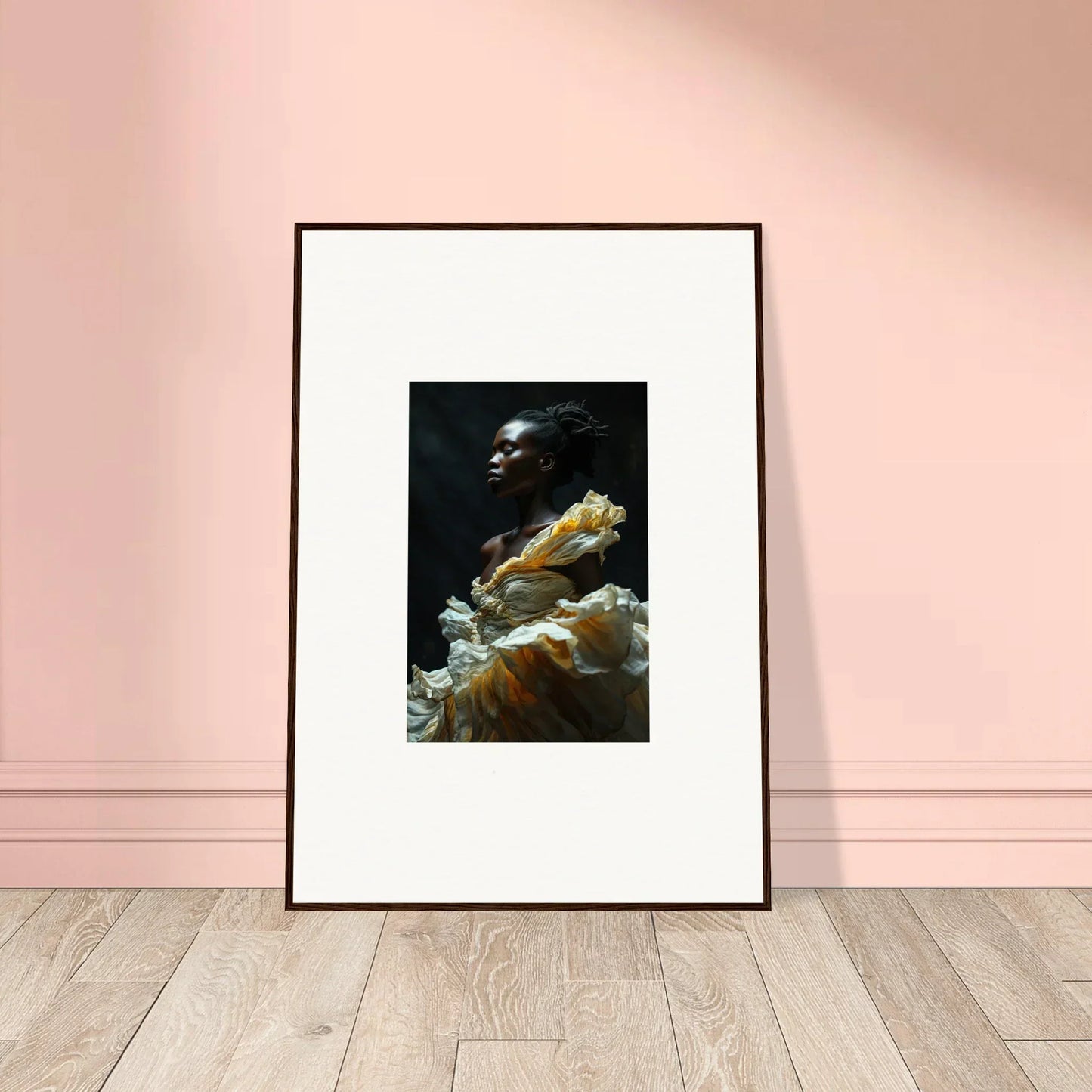 Framed portrait photograph of a person wearing a ruffled yellow garment against a dark background.