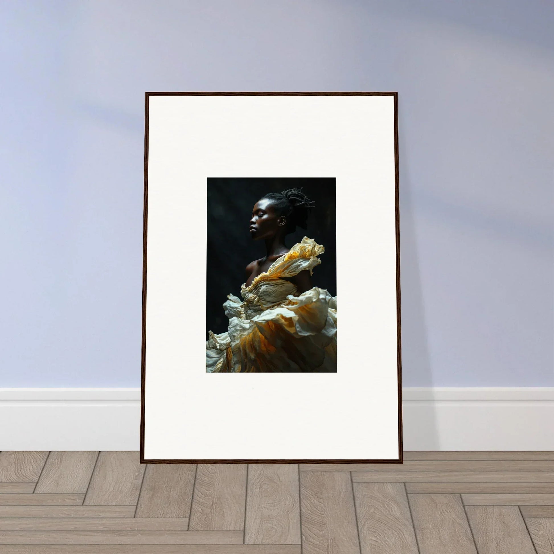 Framed artwork depicting a person with dark skin wearing a flowing yellow garment against a dark background.