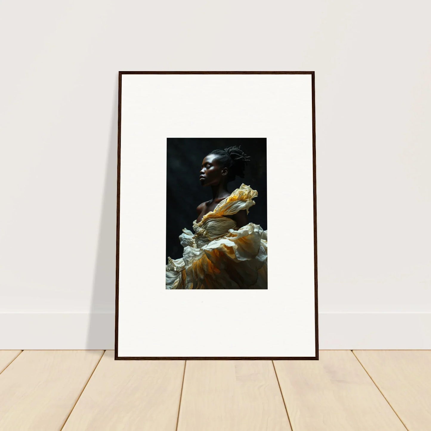 Framed portrait photograph of a person emerging from billowing yellow and white fabric against a dark background.