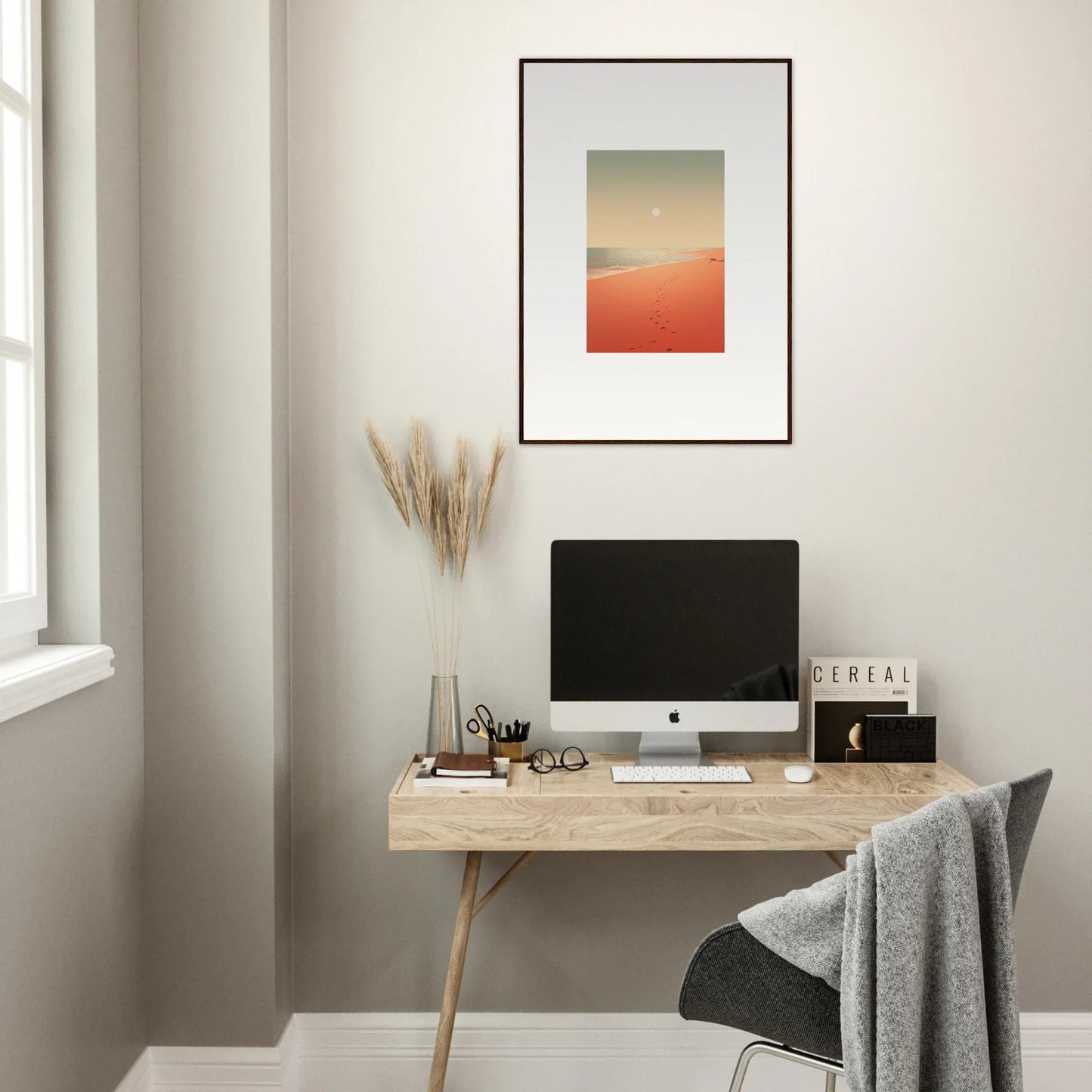 Minimalist wooden desk with computer monitor and framed wall art, enhancing room decor