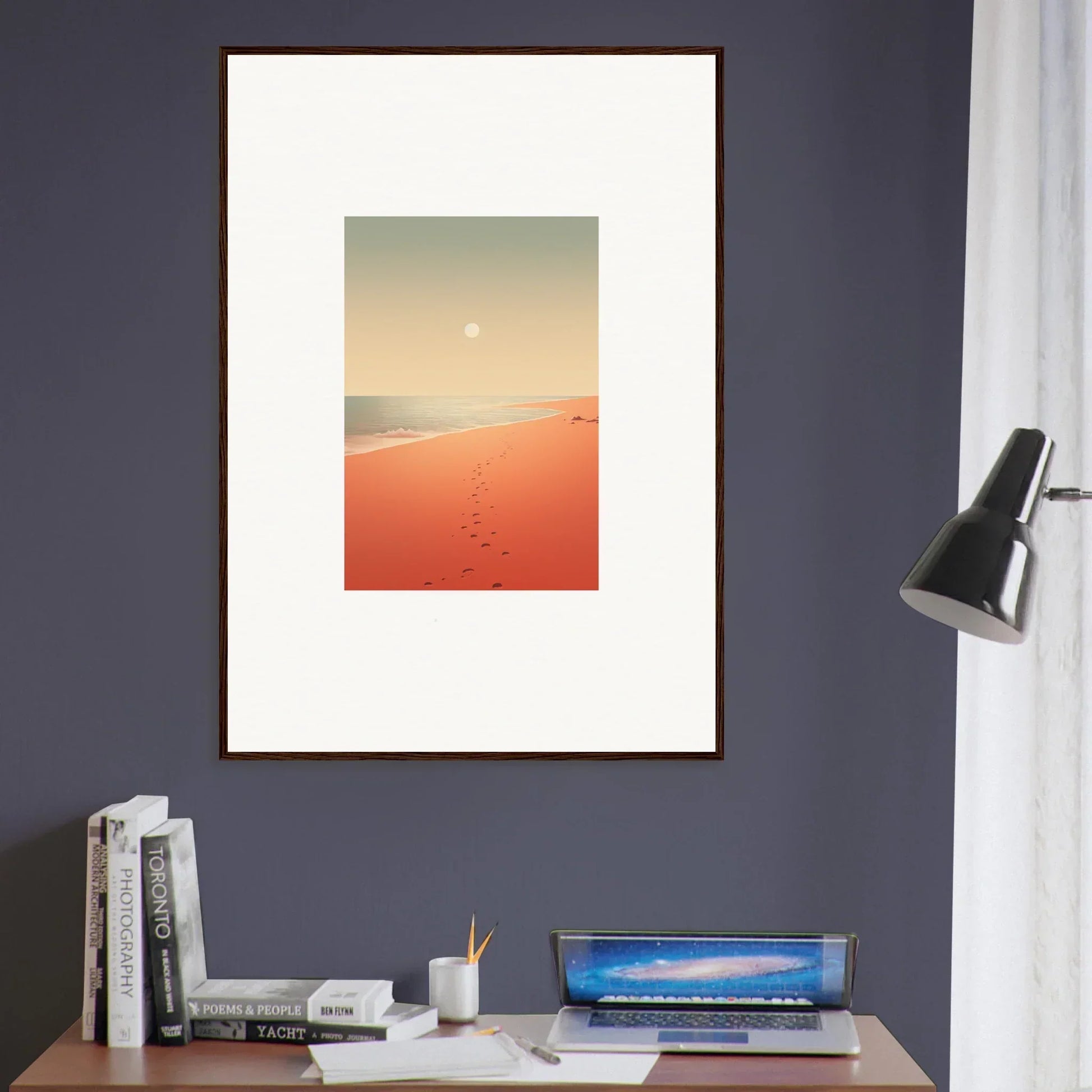 Framed wall art of a desert landscape with red horizons and footprints in orange sand