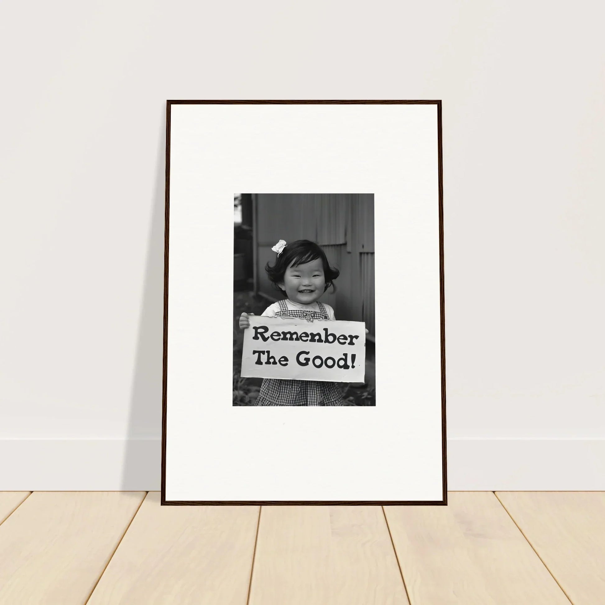 Framed black and white photo of a child with a sign for Remember Joy Essence