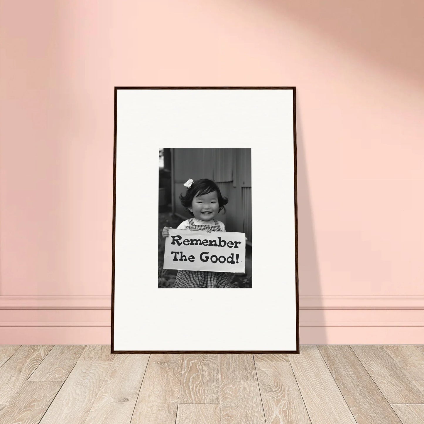 Framed black and white photo of a person with a Remember The Good sign for Remember Joy Essence