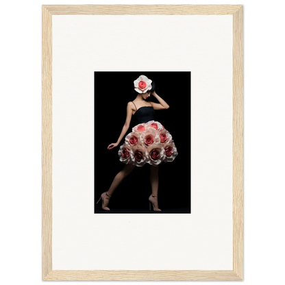 Framed photograph of a figure wearing a dress and headpiece made of red roses against a black background.