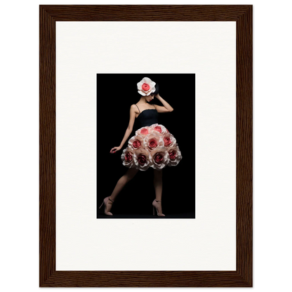 Framed artwork depicting a figure wearing a dress and hat made of red roses against a black background.