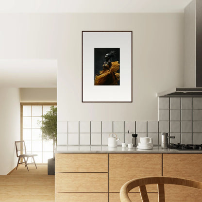 Modern kitchen with wooden cabinetry and framed artwork on the wall.