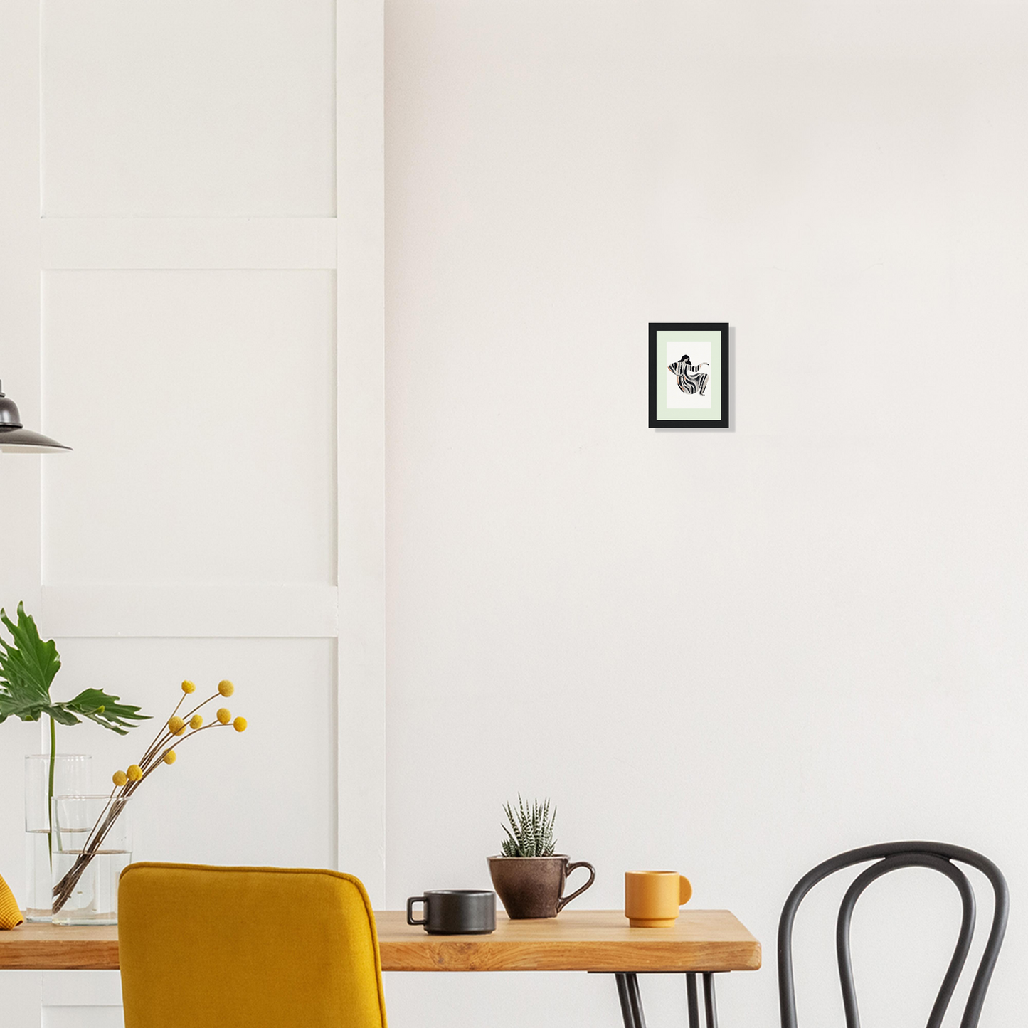 Wooden dining table with a yellow chair and various decorative elements.