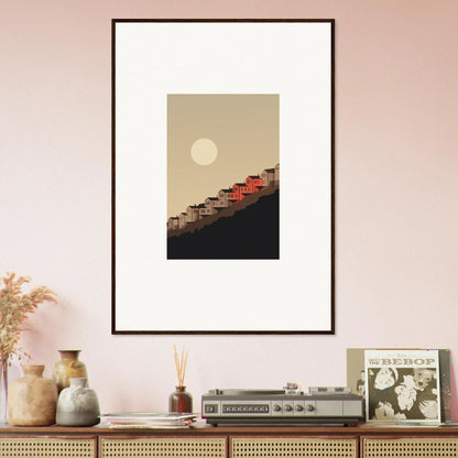 Framed wall art of a minimalist landscape with red-roofed structures for room decor