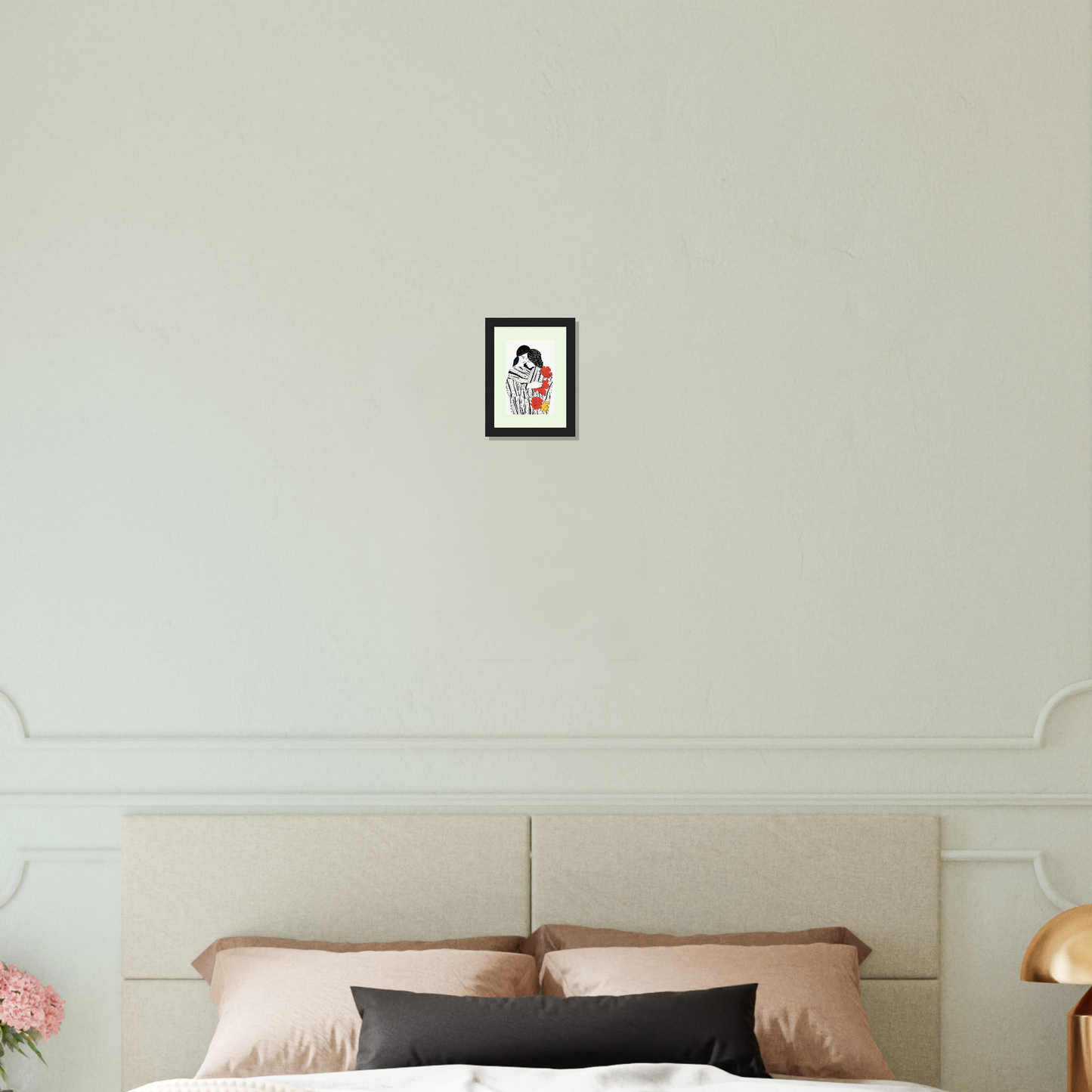 Framed portrait artwork hanging on a wall above a bed.