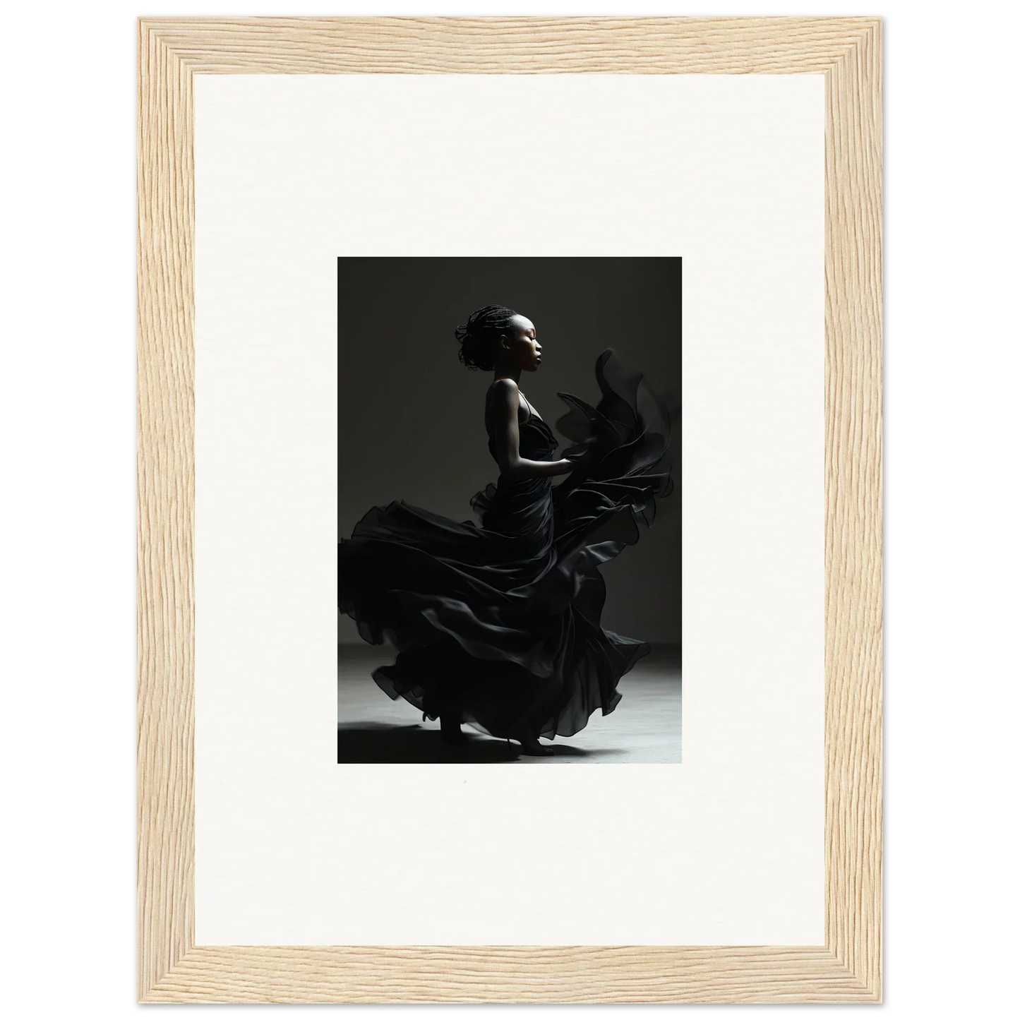 Black and white photograph of a flamenco dancer in motion, framed in a light wooden frame.