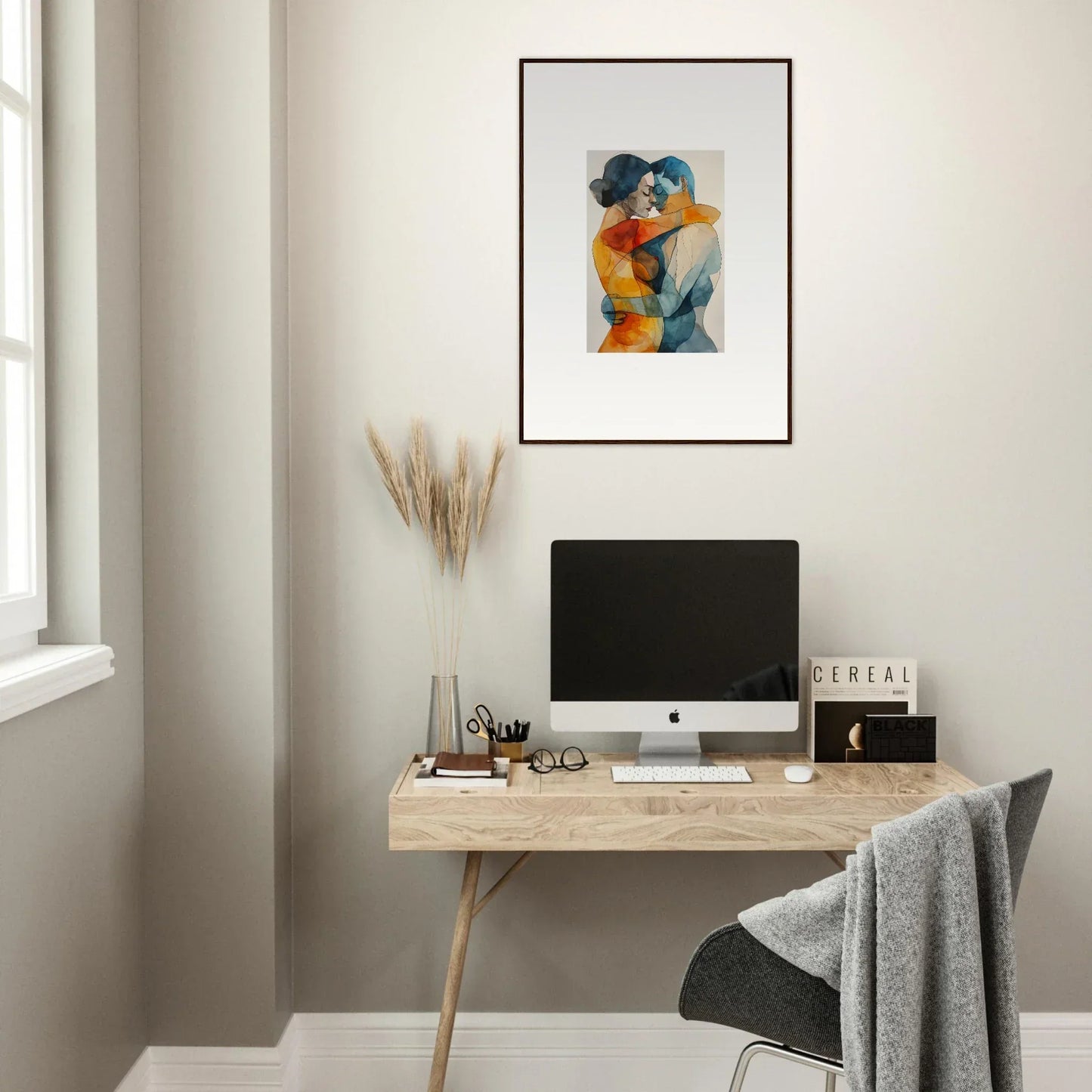 Minimalist home office featuring a wooden desk, computer, and Kaleidoscope Warmutations art