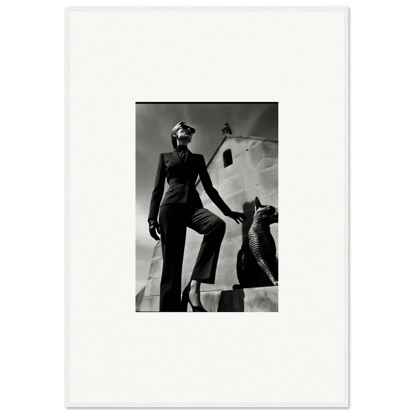 Black and white photograph of a woman in a stylish outfit posing next to a sculptural form.