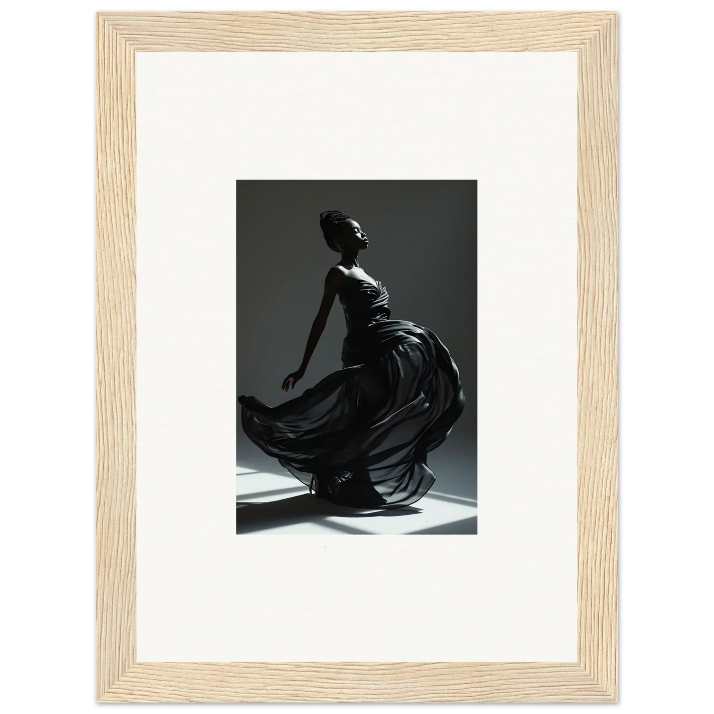 Framed black-and-white photograph of a graceful figure in a flowing dress, captured mid-movement.