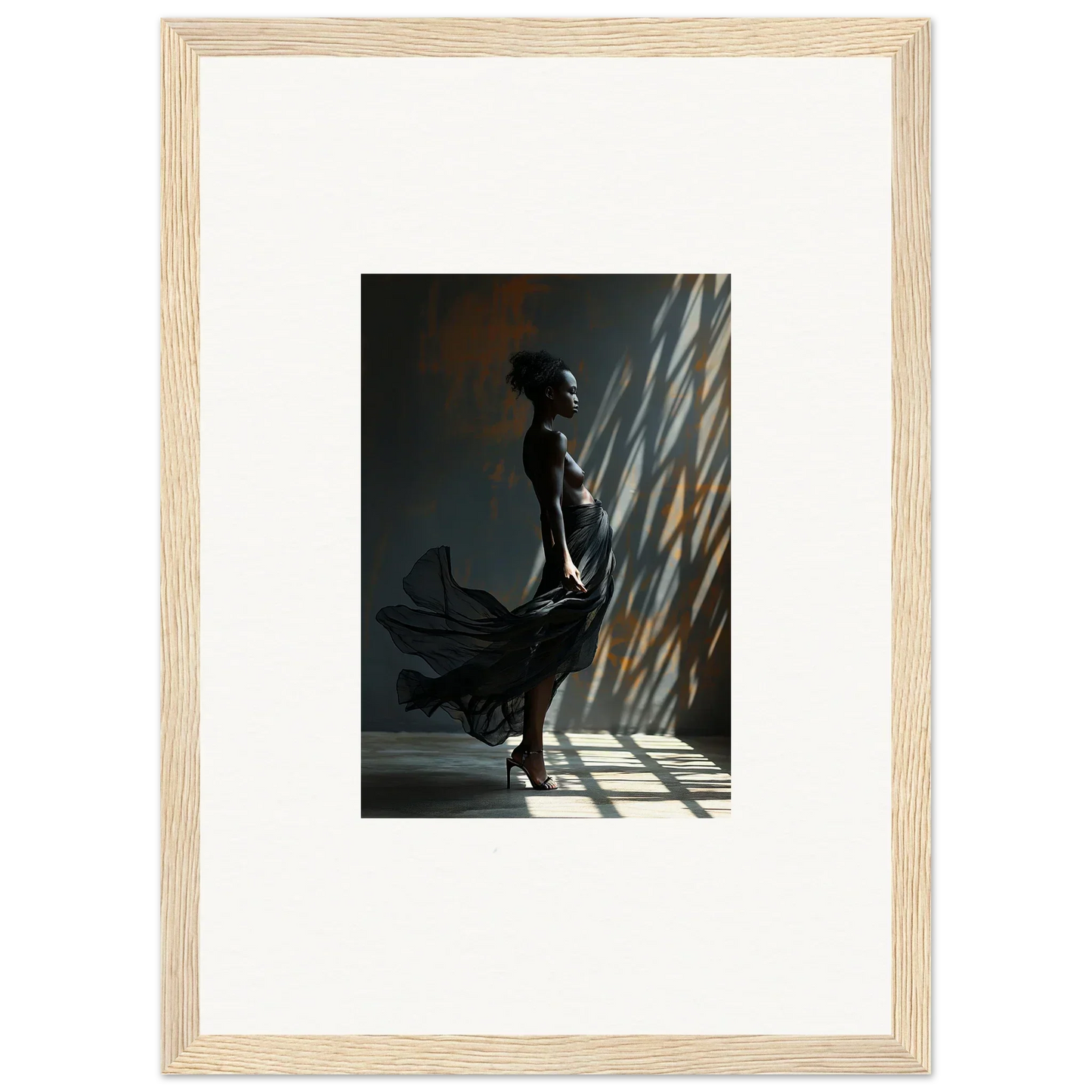 Framed photograph of a silhouetted figure in a flowing dress standing in dramatic light and shadow.