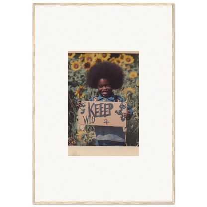 Framed photograph of a child with a KEEP sign in a sunflower field, perfect for room decoration