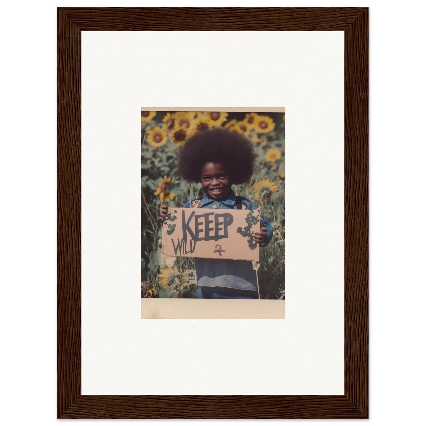 Framed photograph of a person with an afro holding a KEEP sign in a sunflower field for your Freedom Symphony room decoration