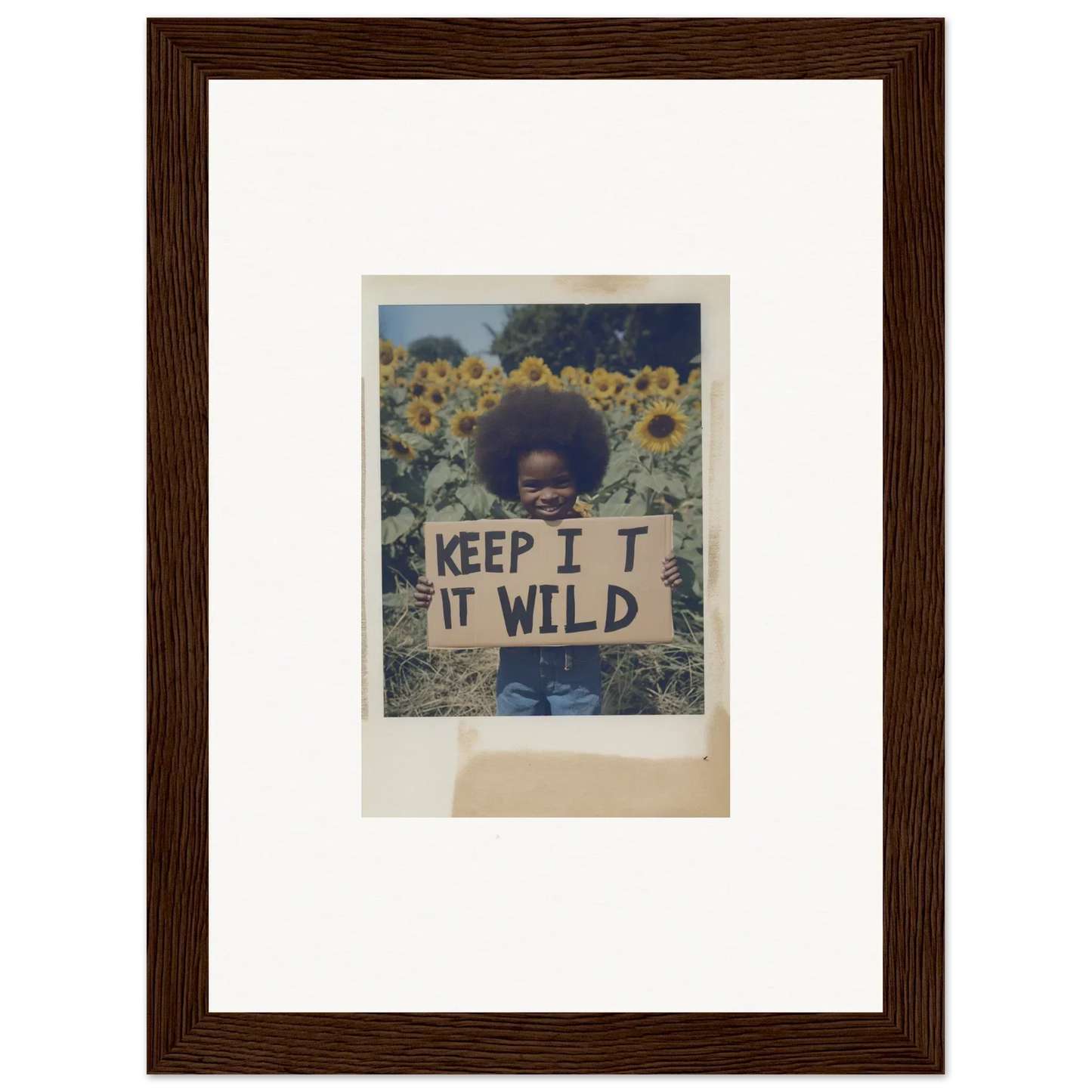 Person holding a KEEP IT WILD sign in a sunflower wilderness field for Sunflower Wilderness Whispers