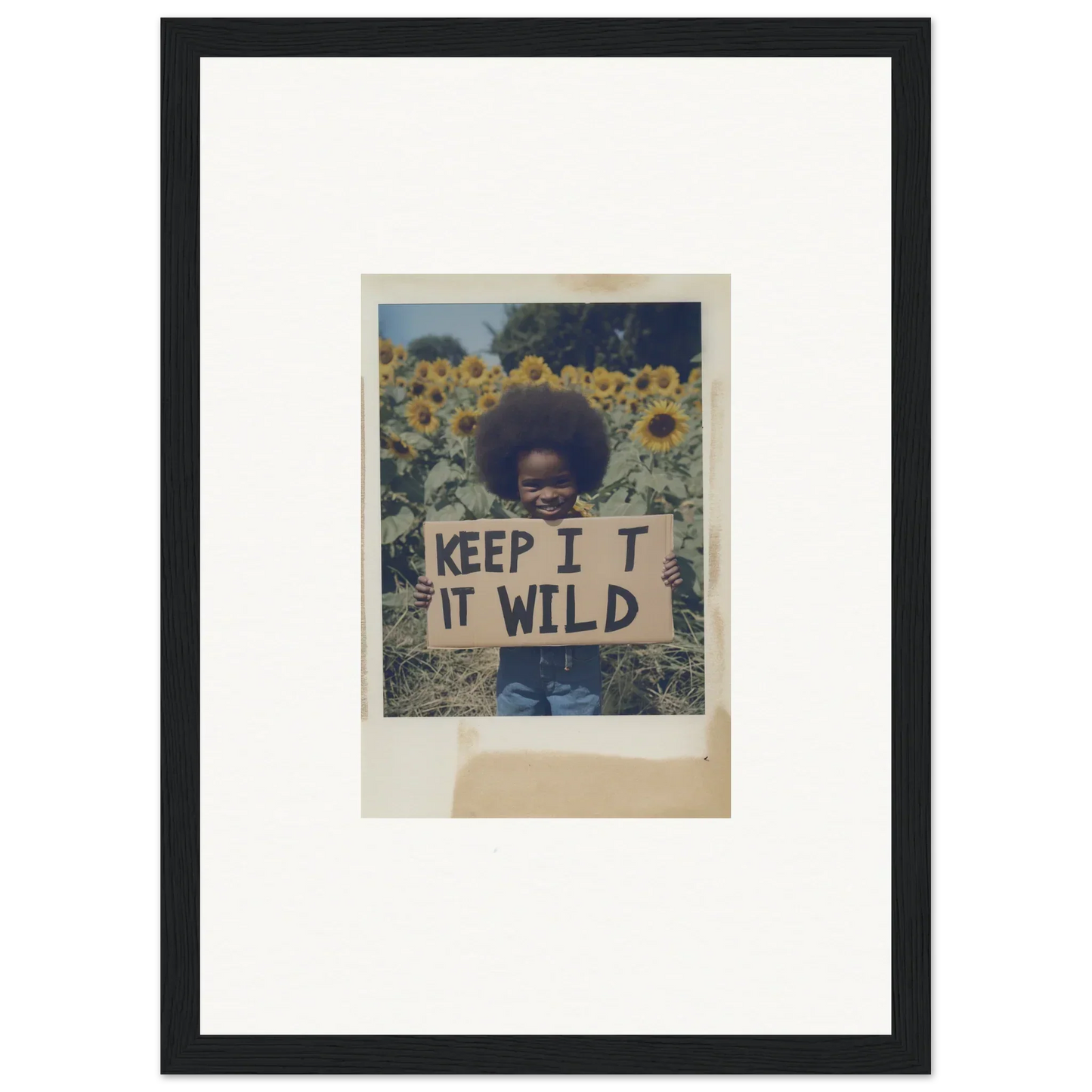 Framed photo of person with KEEP IT WILD sign in Sunflower Wilderness Whispers field