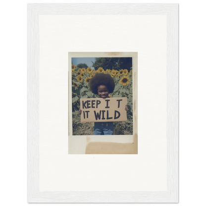 Person holding a KEEP IT WILD sign in a beautiful sunflower wilderness field