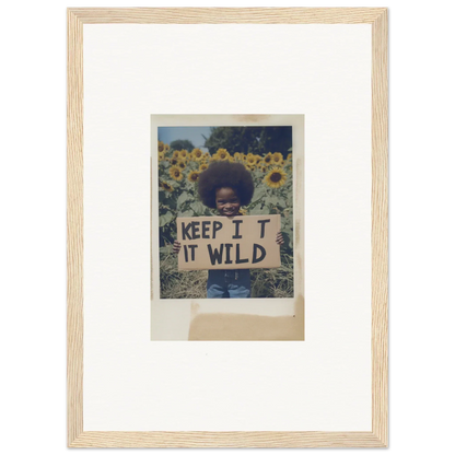 Person holding a KEEP IT WILD sign in a vibrant sunflower wilderness field