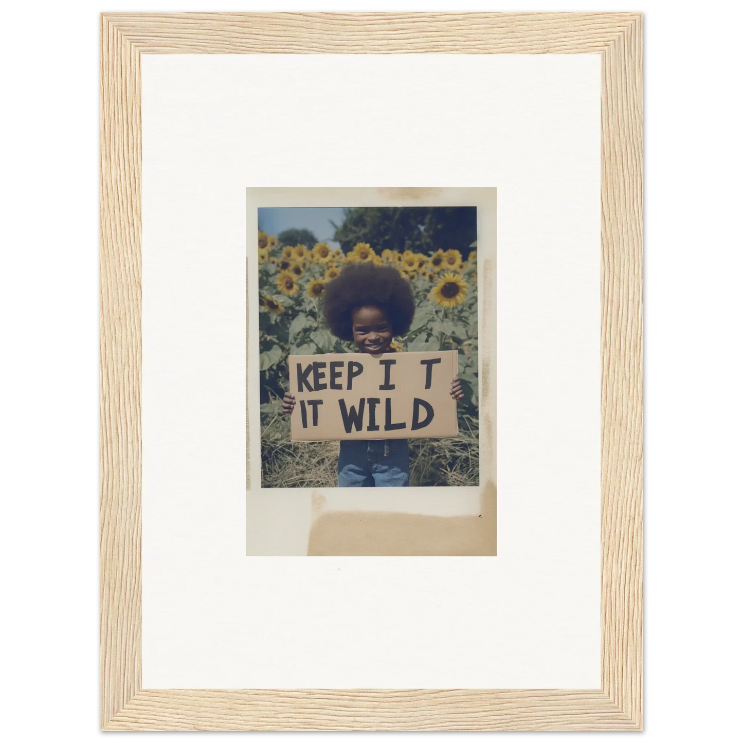 Person holding a KEEP IT WILD sign in a sunflower wilderness field for Sunflower Wilderness Whispers