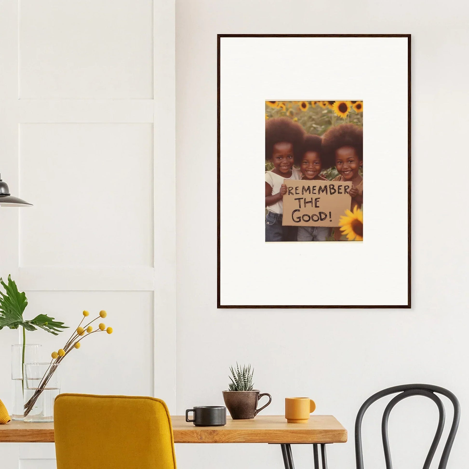 Framed photograph of two people with a Remember the Good sign and sunflowers for room decoration