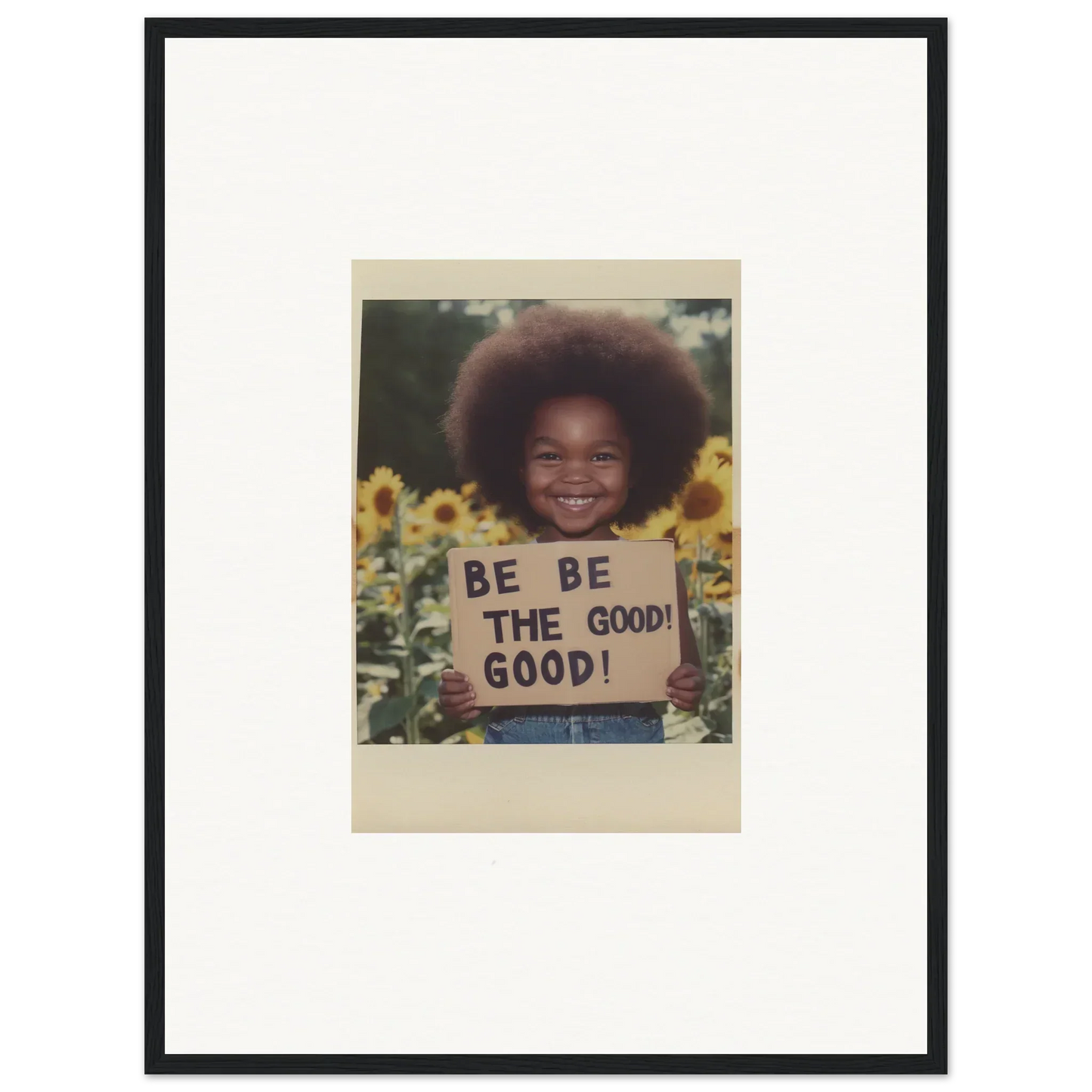 Framed wall art of a child with a BE THE GOOD sign among sunflowers in Sunflower’s Gentle Whisper