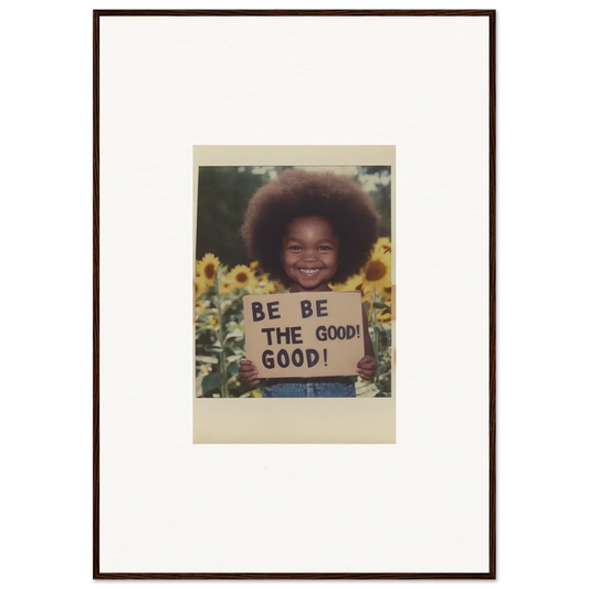 Framed wall art of a person with an afro holding a BE THE GOOD sign in sunflowers