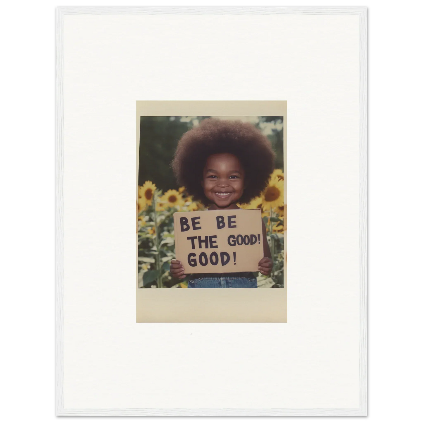 Framed wall art featuring a person with an afro and a BE THE GOOD sign among sunflowers