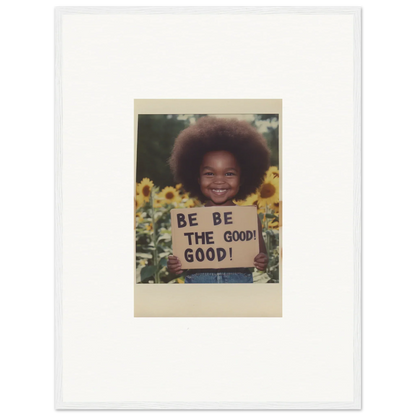 Framed wall art featuring a person with an afro and a BE THE GOOD sign among sunflowers