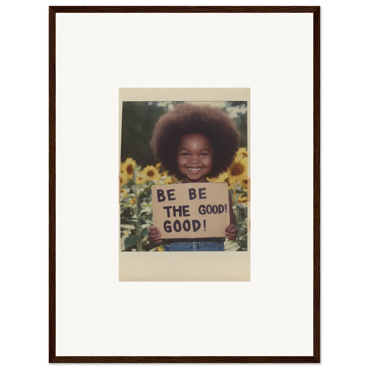 Vintage photo with afro hairstyle, holding BE THE GOOD sign in Sunflower’s Gentle Whisper art